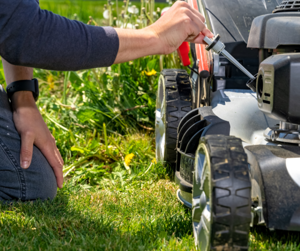 Mężczyzna sprawdza poziom oleju w kosiarce