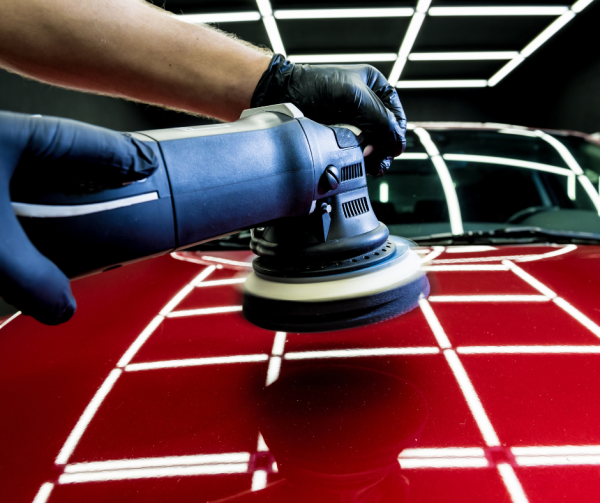 Mężczyzna poleruje czerwony samochód